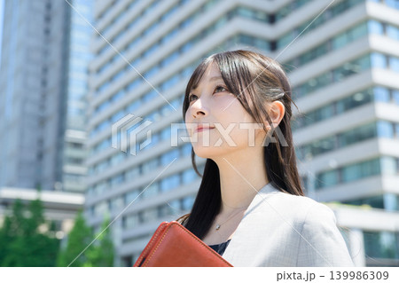ビル街でバインダーを持つ日本人女性 ビル街でバインダーを持つ日本人女性 139986309