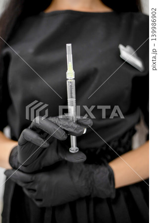 Close up of female hands in medical gloves holding syringe. Healthcare, medicine, vaccination, beauty procedures and cosmetic treatment concept. Aesthetic medicine, skincare, anti-aging and beauty 139986902