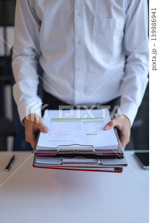 Businessman working in office carrying stack of documents. Businessman working in office carrying stack of documents. 139986941