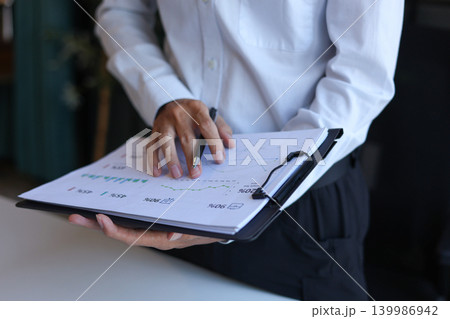 Businessman working in office reading documents analyze data for project planning. Businessman working in office reading documents analyze data for project planning. 139986942