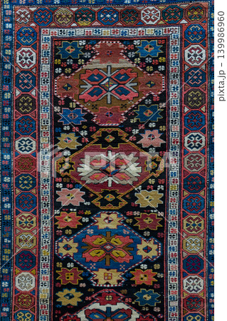 Authentic traditional Karabakh type carpet from Azerbaijan featuring detailed ornamental motifs, rich woven texture, and colorful Caucasian craftsmanship. Decorative oriental rug inspired by 139986960