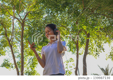 Young Woman Enjoying Music While Walking Exercise Outdoors. Young Woman Enjoying Music While Walking Exercise Outdoors. 139987130