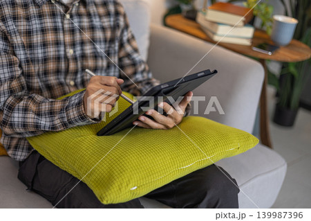 Close up of creative freelancer working on touch screen tablet. Close up of creative freelancer working on touch screen tablet. 139987396