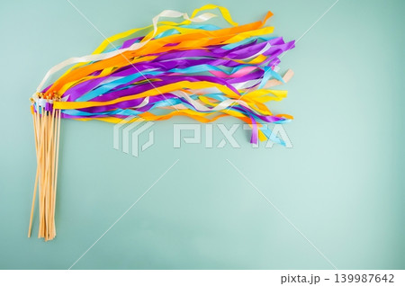 Colorful Rainbow Ribbon Wand with Wooden Sticks on Light Blue Background Colorful Rainbow Ribbon Wand with Wooden Sticks on Light Blue Background 139987642