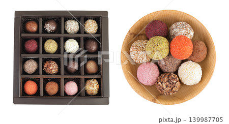 A variety of different truffles in a box and wooden bowl Isolated on a white background. Top view. Flat lay A variety of different truffles in a box and wooden bowl Isolated on a white background. Top view. Flat lay 139987705