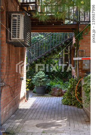 Cozy courtyard or alley between brick buildings, likely in Tbilisi Cozy courtyard or alley between brick buildings, likely in Tbilisi 139987996