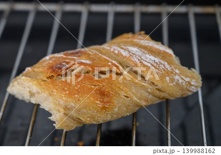 Freshly baked bread resting on a cooling rack, capturing warmth and texture in a cozy kitchen setting 139988162