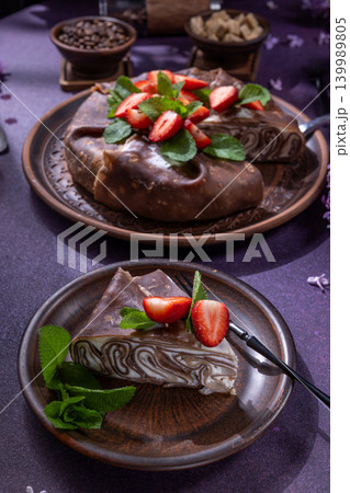Chocolate crepe cake with strawberries and mint leaves Chocolate crepe cake with strawberries and mint leaves 139989805