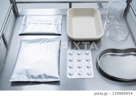 Medical supplies and packaging arranged on a sterile stainless steel tray Medical supplies and packaging arranged on a sterile stainless steel tray 139989954