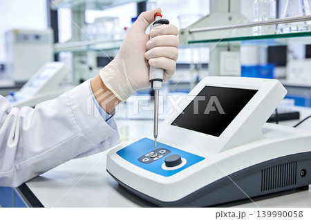 Scientist using a pipette and modern laboratory equipment for research Scientist using a pipette and modern laboratory equipment for research 139990058