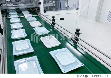 Automated packaging line for sterile medical trays on a conveyor belt Automated packaging line for sterile medical trays on a conveyor belt 139990083