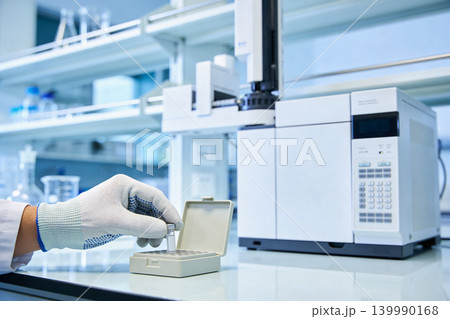 Scientist handling samples in a modern laboratory with advanced analytical equipment Scientist handling samples in a modern laboratory with advanced analytical equipment 139990168