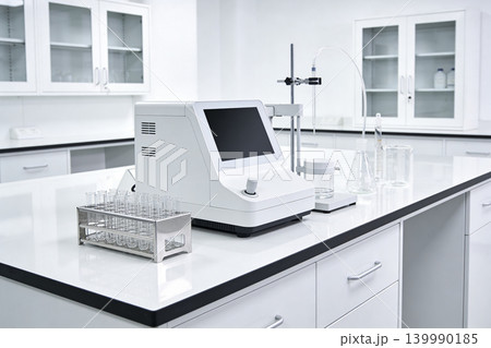 Modern laboratory equipment with digital display and test tubes on a clean white bench Modern laboratory equipment with digital display and test tubes on a clean white bench 139990185