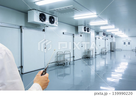 Professional inspecting a sterile cold storage facility with climate control systems Professional inspecting a sterile cold storage facility with climate control systems 139990220