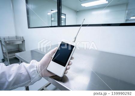 Scientist holding a handheld device with antenna in a sterile laboratory environment 139990292