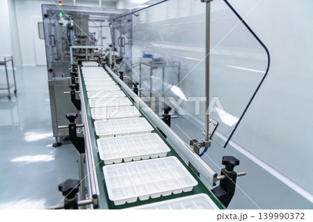 Automated production line with empty trays moving on a conveyor belt 139990372