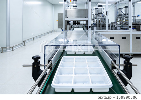 Automated production line with conveyor belt and empty trays in a cleanroom environment Automated production line with conveyor belt and empty trays in a cleanroom environment 139990386