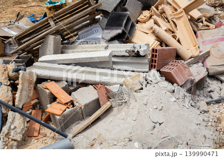 Pile of construction debris and building materials scattered outdoors Pile of construction debris and building materials scattered outdoors 139990471
