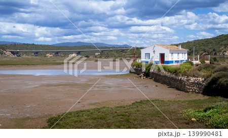 Coastal landscape with a white house and a bridge over a tidal river Arade Portugal Coastal landscape with a white house and a bridge over a tidal river Arade Portugal 139990481