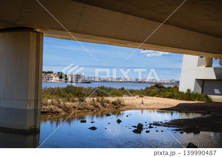 View of Portimao coastal city skyline through a concrete Arade bridge structure View of Portimao coastal city skyline through a concrete Arade bridge structure 139990487