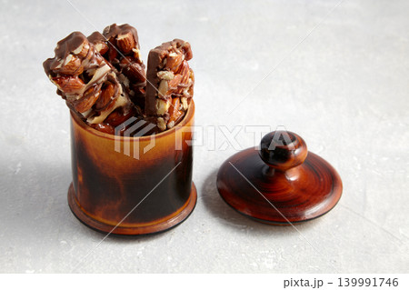 chocolate bars with nuts and caramel in a wooden bowl 139991746