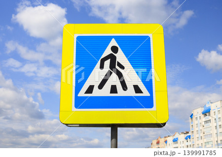 Pedestrian crossing sign on an outdoor metal pole. Informational indicator for ensuring safety on city streets and regulating pedestrian traffic. 139991785