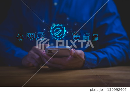 Man using smartphone for online banking with security shield. Financial protection for digital payment, money transfer, and safe e-commerce cyber security technology. Man using smartphone for online banking with security shield. Financial protection for digital payment, money transfer, and safe e-commerce cyber security technology. 139992405