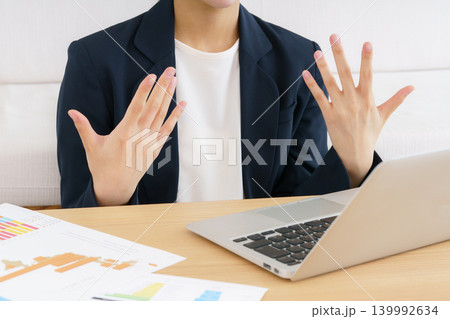 ノートパソコンでビデオ通話する若い日本人女性の身振り手振りの手元のアップ ノートパソコンでビデオ通話する若い日本人女性の身振り手振りの手元のアップ 139992634