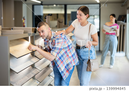 Young married couple chooses laminate flooring together in hardware store 139994845