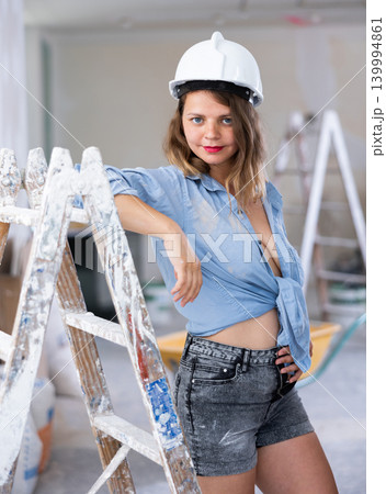 Tempting woman in revealing attire posing in construction site Tempting woman in revealing attire posing in construction site 139994861