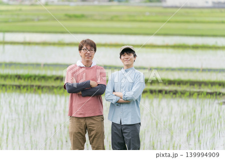 田んぼの畦道に立つ2人の農家 田んぼの畦道に立つ2人の農家 139994909
