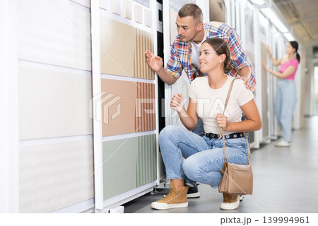 Couple of man and woman choose tiles in store Couple of man and woman choose tiles in store 139994961
