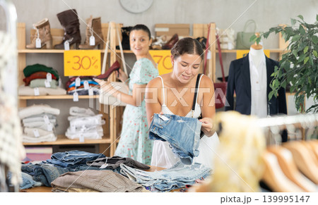 Young woman choosing jean shorts in clothing store 139995147