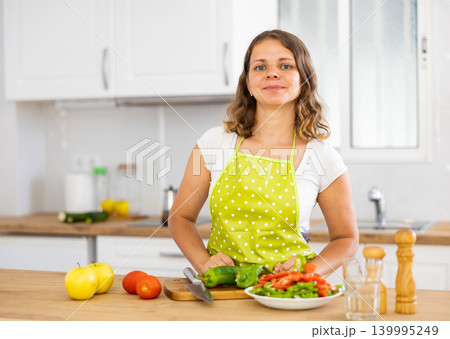 Young woman cutting fresh vegetables for salad Young woman cutting fresh vegetables for salad 139995249