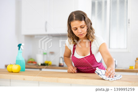 Housewife using rag to wash kitchen table Housewife using rag to wash kitchen table 139995259