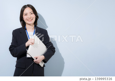 パソコンを持つ働くかわいい女性社員のビジネスとITなどのイメージ　カメラ目線笑顔 139995316