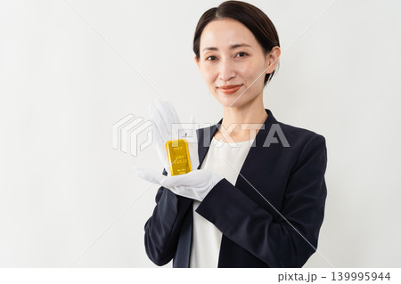 インゴットを持っているビジネススーツの女性 ブランドイメージ インゴットを持っているビジネススーツの女性 ブランドイメージ 139995944