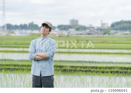 腕組みをして考える若いコメ農家 139996041