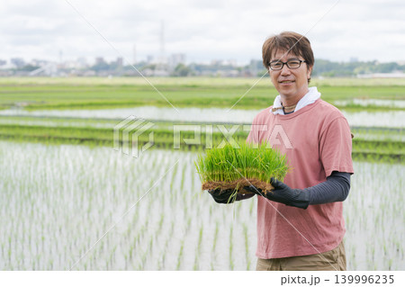 米の苗を持つ農家の男性 139996235