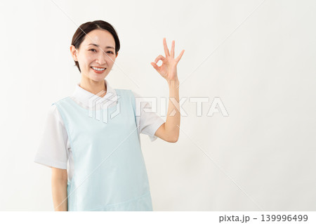 水色のエプロンを着た女性　介護士イメージ 139996499