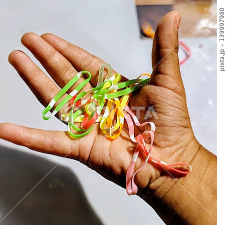 little child's hand holding colorful hair tie 139997980