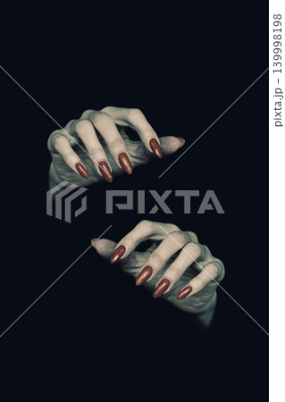 Witches pale knotty hands with sharp long nails in the dark, low key, vertical image. Happy Halloween theme. 139998198