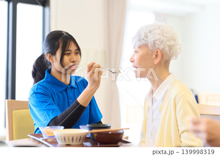 シニアの食事介助をする外国人介護士 シニアの食事介助をする外国人介護士 139998319