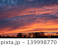 Spectacular sunset sky with vibrant orange and purple clouds over trees 139998770