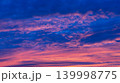 Dramatic colorful sunset clouds glowing across deep blue evening sky 139998775