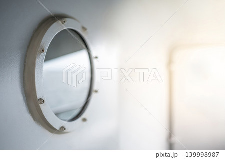 Round porthole window with rivets on heavy metal door of ship Round porthole window with rivets on heavy metal door of ship 139998987