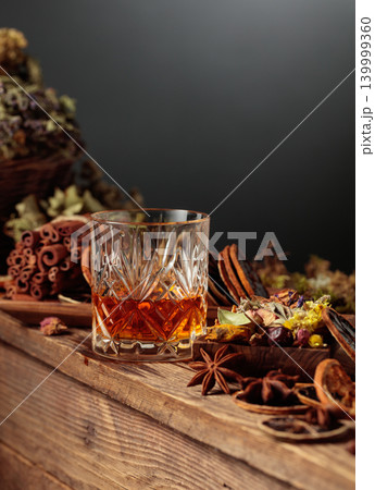 Herbal liquor is poured from a vintage bottle into a glass. Herbal liquor is poured from a vintage bottle into a glass. 139999360