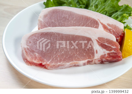 豚肉の厚切りステーキが白い皿に盛られた食材 豚肉の厚切りステーキが白い皿に盛られた食材 139999432