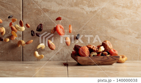 Mix of dried fruits and nuts in motion. 140000038
