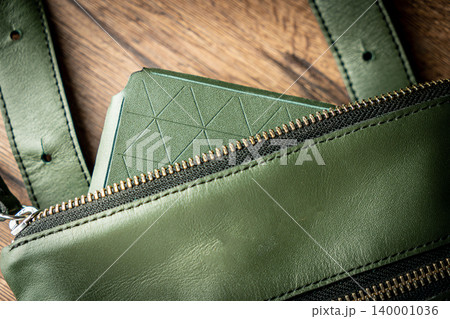 Fashionable mens bag, men purse, wallet men's casual outfits with leather accessories, brown bag on wooden board background Fashionable mens bag, men purse, wallet men's casual outfits with leather accessories, brown bag on wooden board background 140001036
